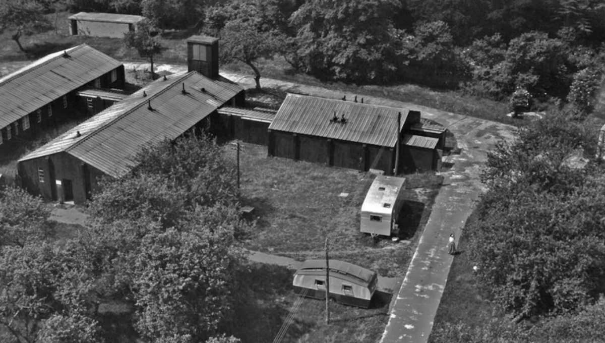 An above view of three connected tin shacks and two caravans- these served as offices and rooms form Defford Airfield teams.